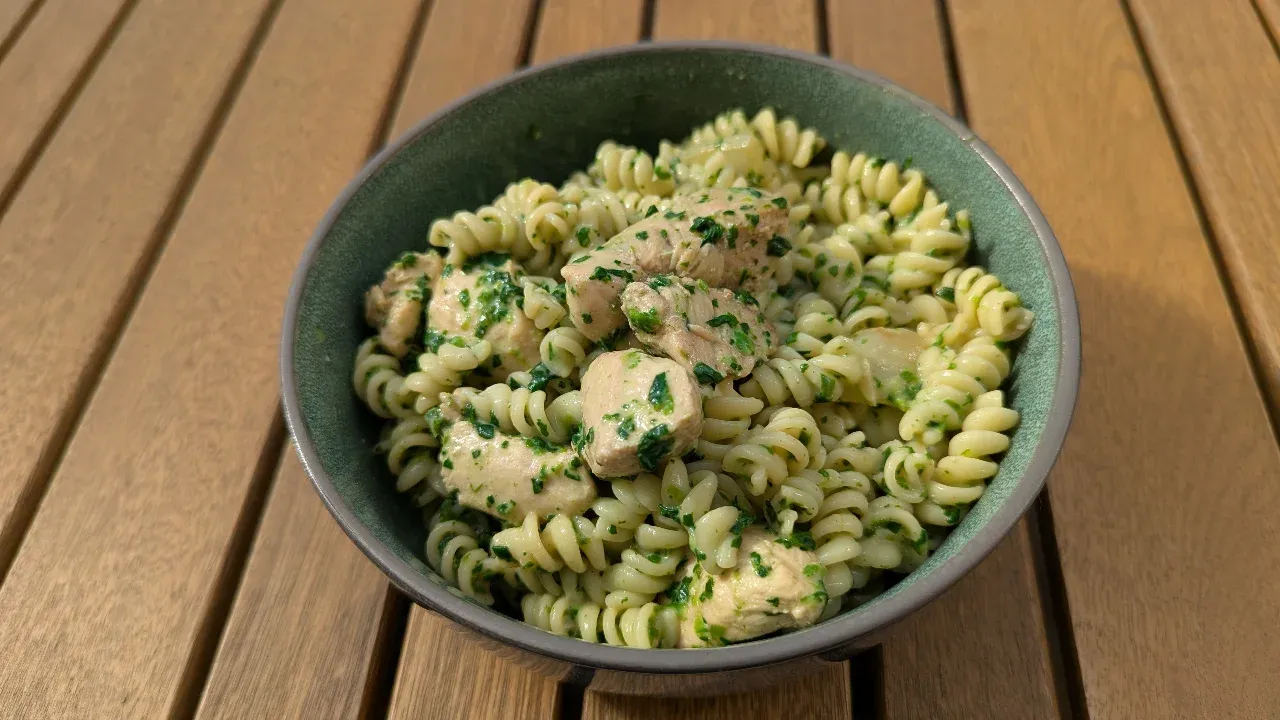 Cremige Fusilli-Pfanne mit Hähnchen und Spinat in einem Wok.