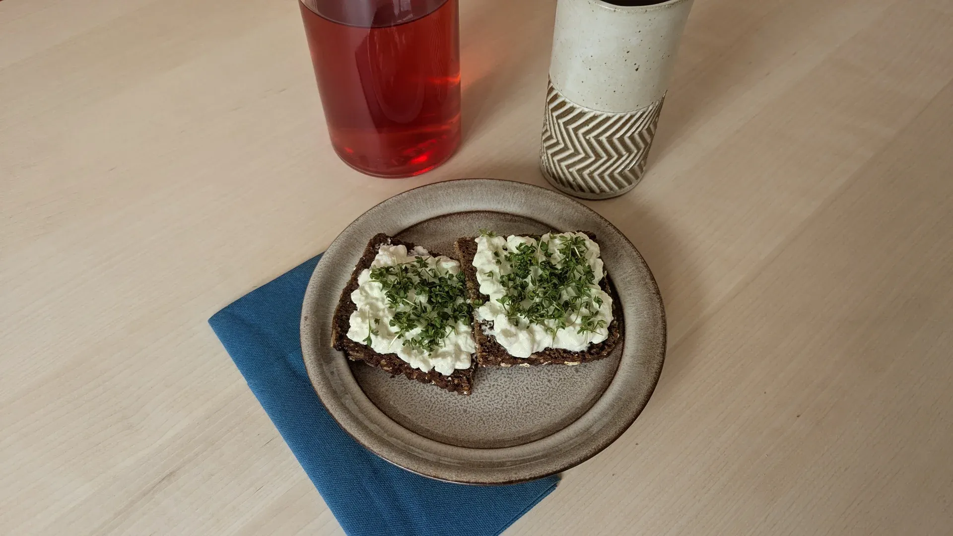 Schwarzbrot mit Hüttenkäse und Kresse auf einem Holzbrett